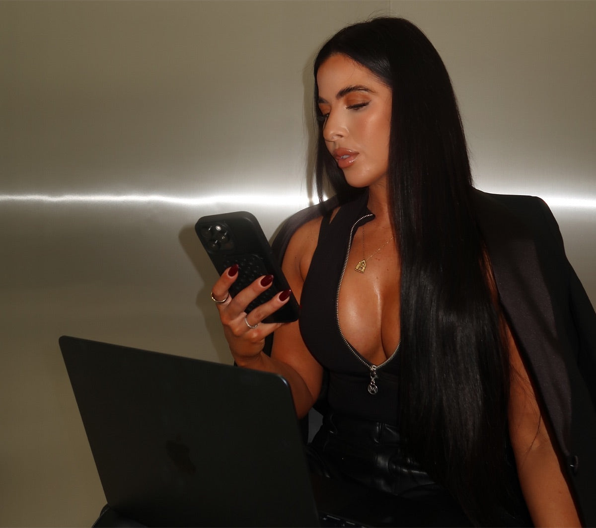 Henny Moody, founder of Feel Good Naked, checking her phone at her laptop